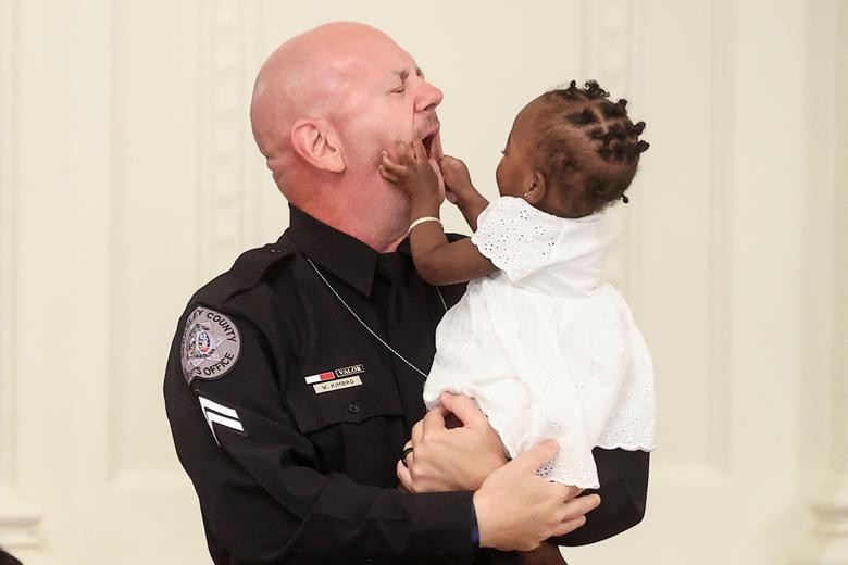 One-year-old Ryleigh Boyd grabs the face of Berekely County Sheriff's Deputy William Kimbro during a roundtable discussion on law enforcement hosted by U.S. President Donald Trump in the East Room of the White House in Washington. Kimbro is credited with saving the life of young Ryleigh during a traffic stop in 2019. REUTERS/Jonathan Ernst  